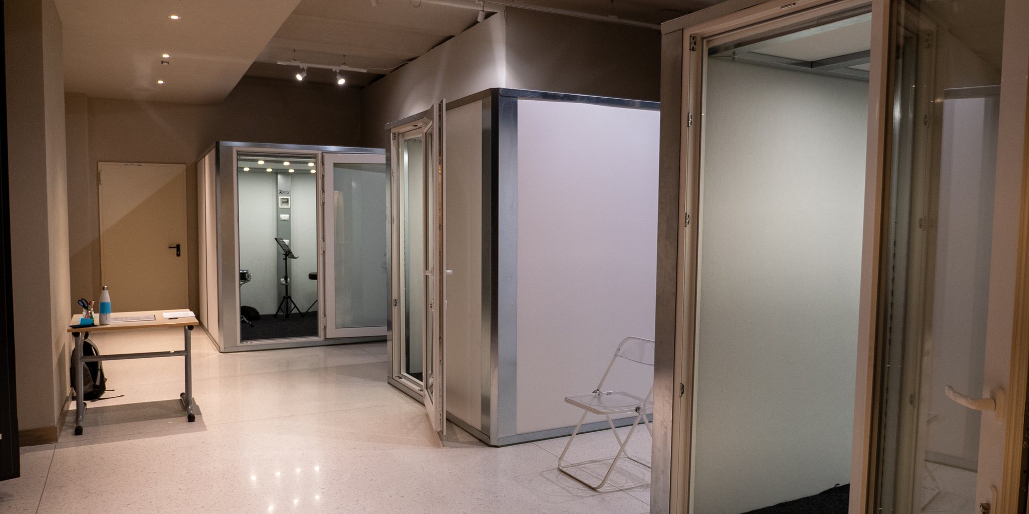 Il corridoio di XNL Musica con le sale modulari: cabine insonorizzate con le porte a vetri aperte.