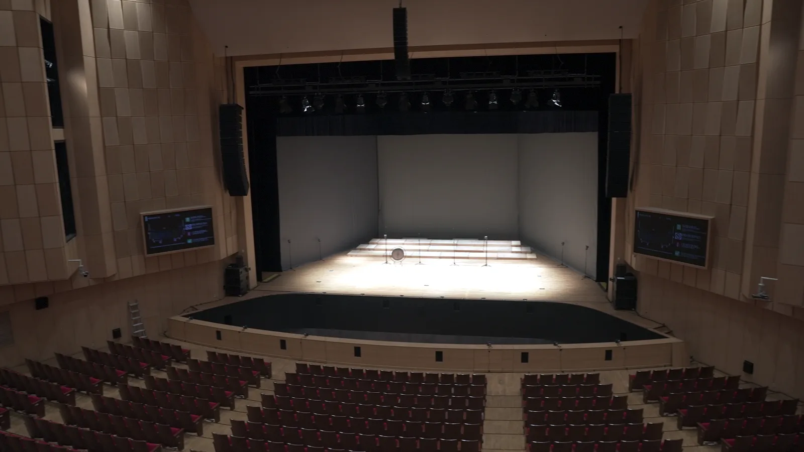 The Keimyung Art Center seen from the stalls: the red seats, the orchestra pit, the black proscenium and on stage the lit white room, between the pale wooden walls.